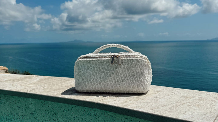 Bouclé cosmetic case on holiday – best travel makeup bag for skincare and makeup lovers.